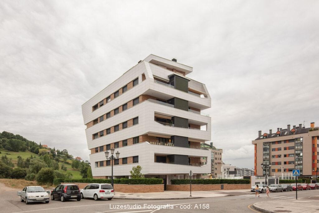 Edificio Finlandia en Oviedo 8 edificio residencial en oviedo fotografiado por los fotógrafos de arquitectura de luzestudio en un dia nublado con dos personas cruzando delante