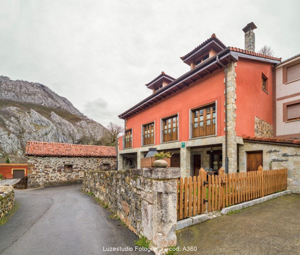 casa rural en asturias con fachada renovada en pueblo con vallas de piedra y con vistas a la montaña